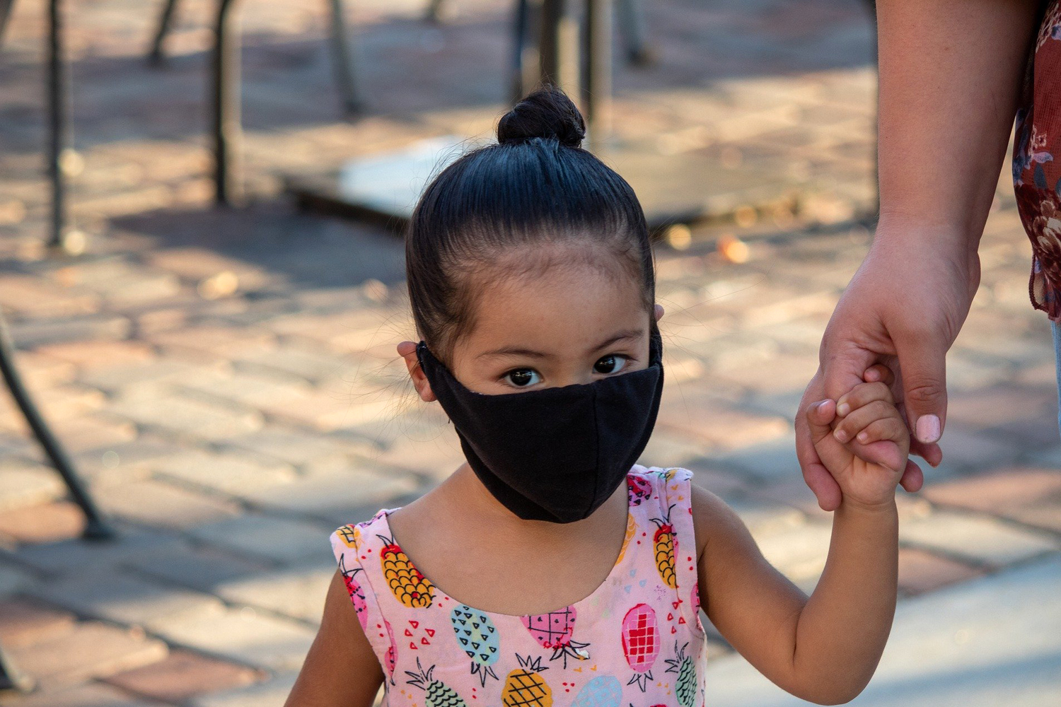 Mascarillas para niños. Una niña con mascarilla acompaña a su madre