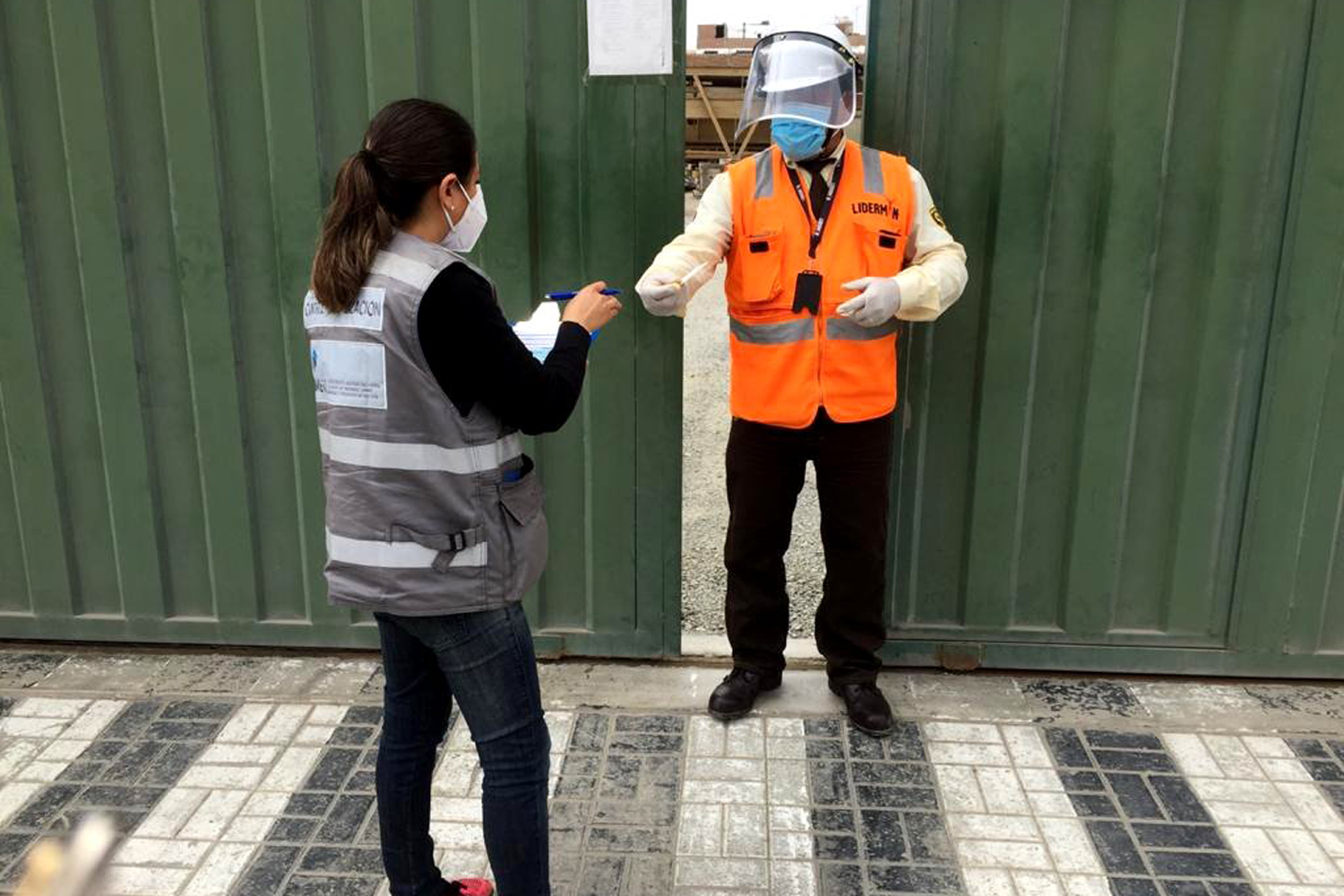 un vigilante de seguridad privada protegido con careta, mascarilla y guantes en Perú