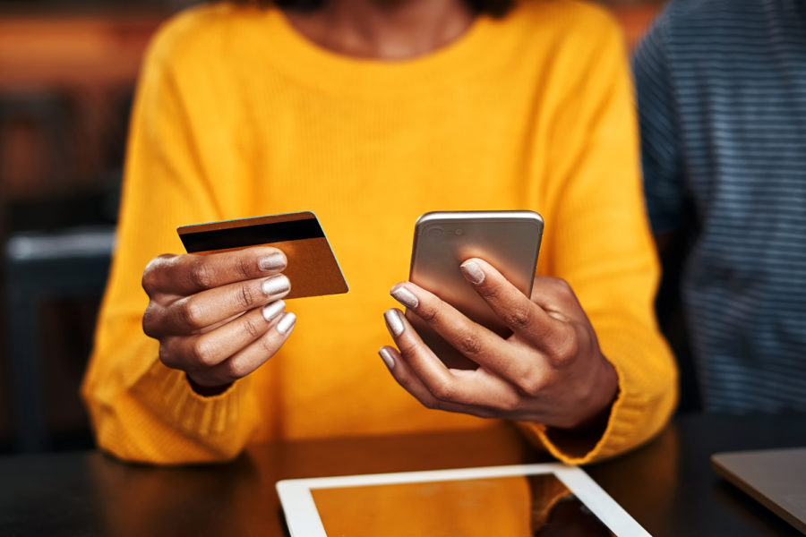 ciberseguridad una mujer consulta un smartphone y su tarjeta bancaria