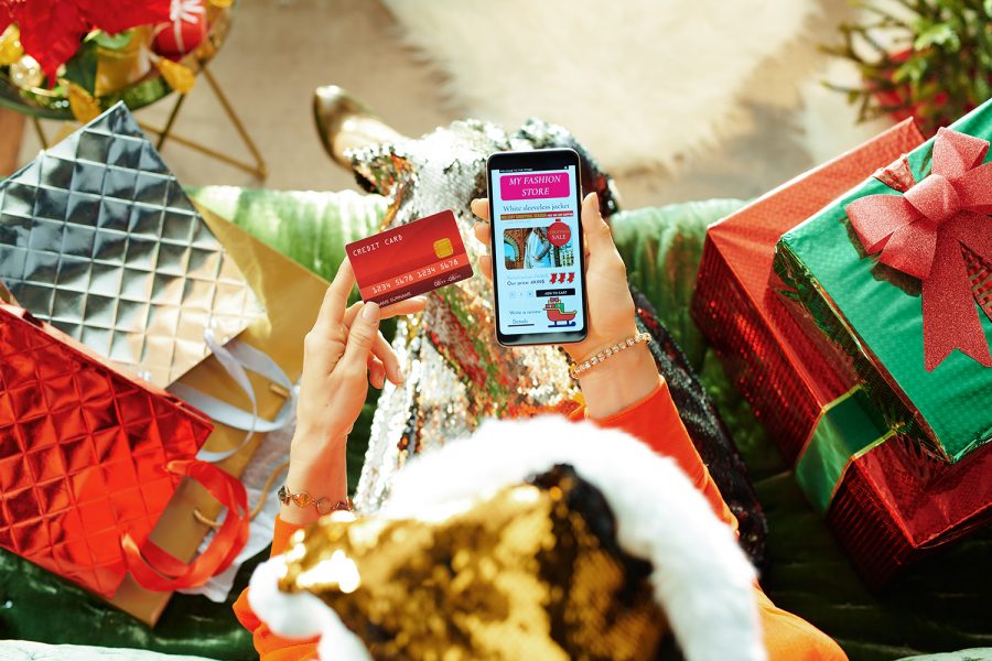 una mujer realiza compras en línea con su smartphone en Navidad