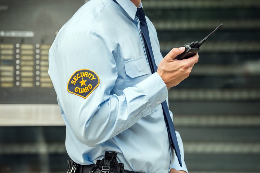un guardia de vigilancia y seguridad privada comunicándose a través de su radio