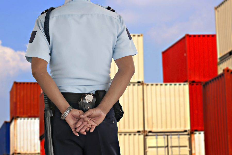 un guardia de seguridad privada vigila un centro logístico de contenedores