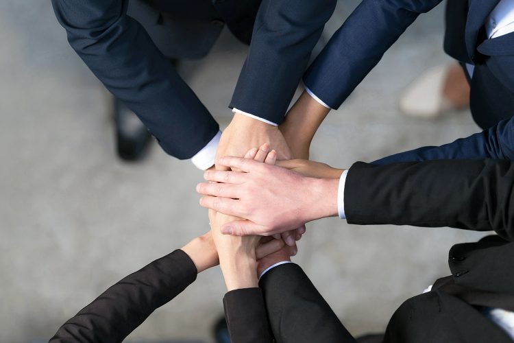 un grupo de empresarios junta sus manos