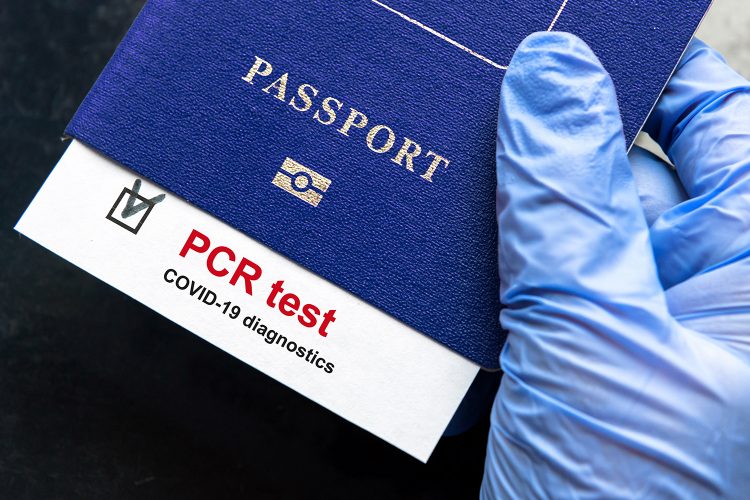 un pasaporte y un test PCR de COVID-19