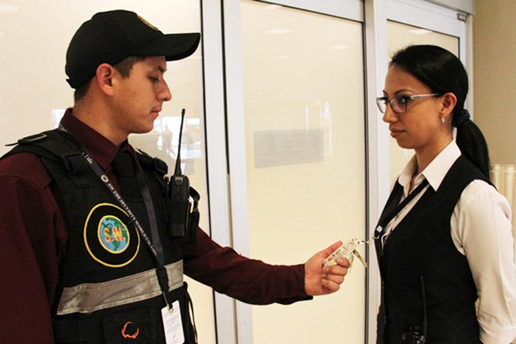 Un guardia de seguridad comprueba la credencial de una empleada en un aeropuerto ecuatoriano