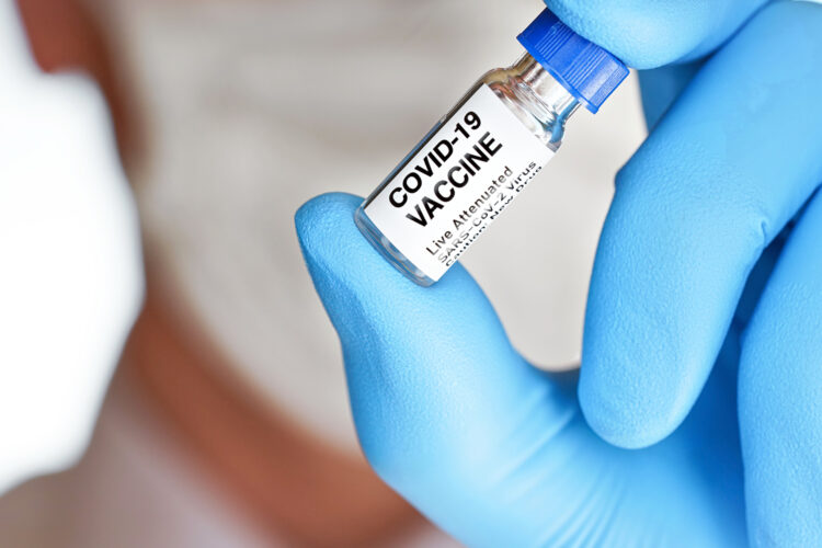 una persona sujeta un frasco con la vacuna contra la COVID-19