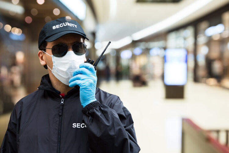 un guarda de seguridad privada se comunica por radio en un centro comercial