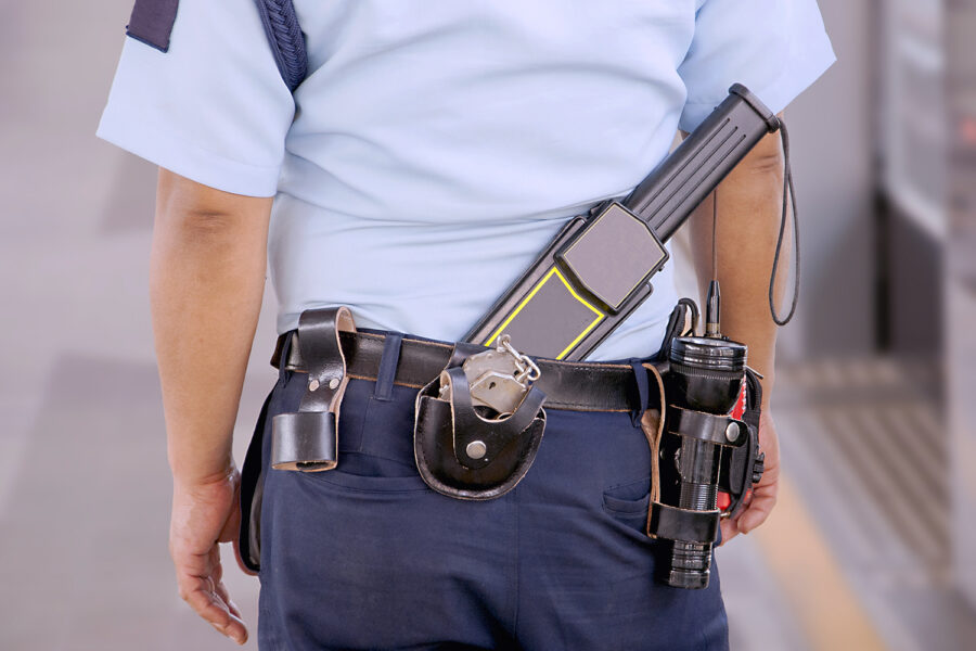 un guarda de seguridad privada de espaldas con equipamiento
