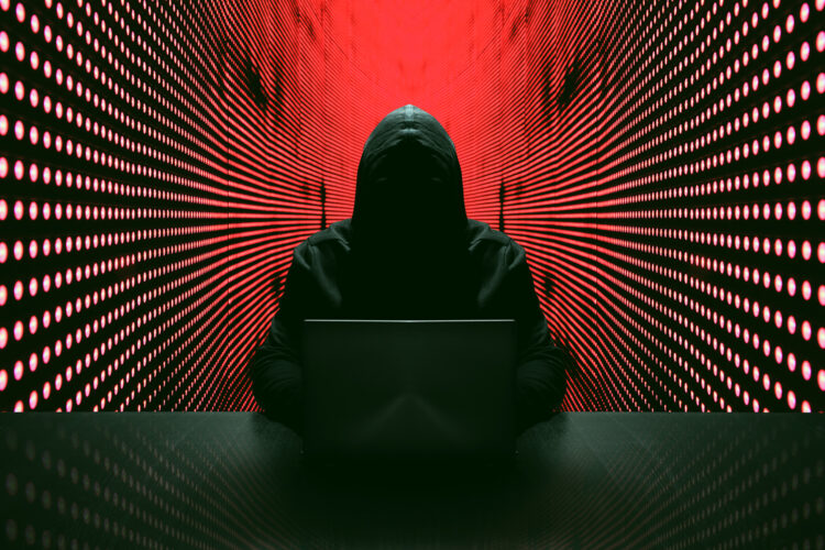 hacker informático encapuchado con una ladtop