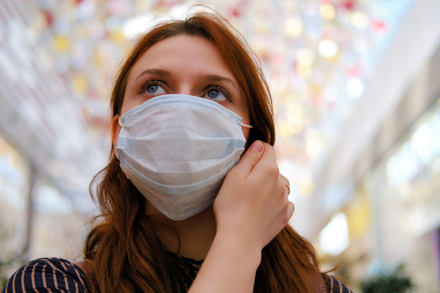 una mujer con mascarilla quirúrgica en un centro comercial