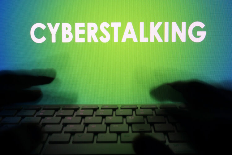 un acosador practica cyberstalking con su computadora