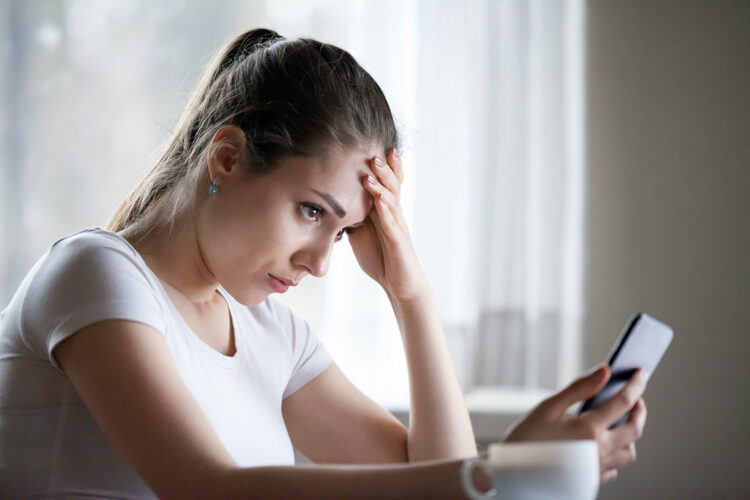 una mujer consulta su smartphone con preocupación
