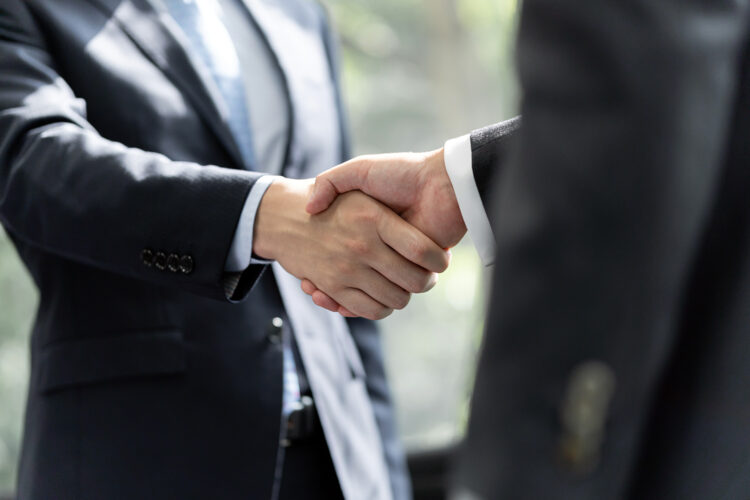 dos hombres sellan un acuerdo de negocios con un apretón de manos