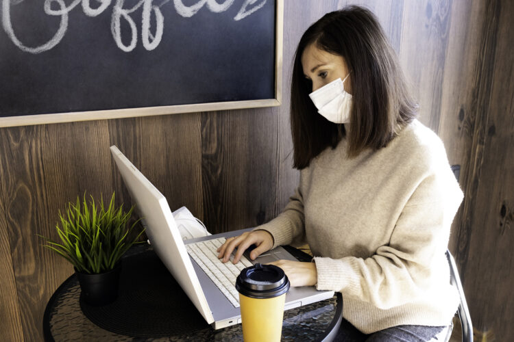 una mujer practica trabajo híbrido en una cafetería