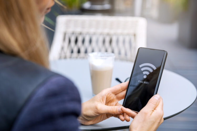 una mujer se conecta a una red wifi abierta con su celular