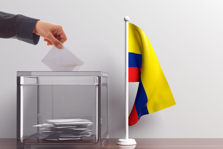 un votante deposita su voto en una urna de las elecciones de Colombia