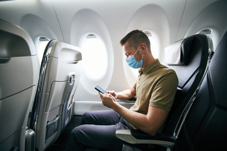 un pasajero con mascarilla en un avión