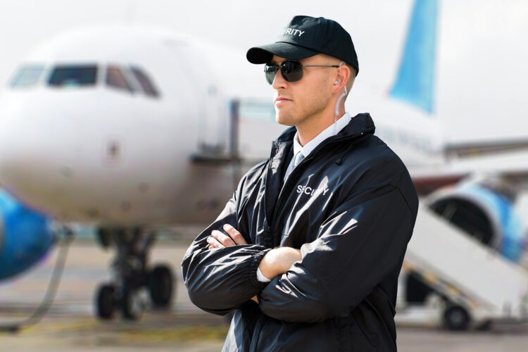 vigilante de seguridad privada junto a un avión de pasajeros