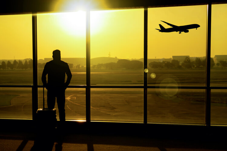 un viajero en un aeropuerto observa el despegue de un avión
