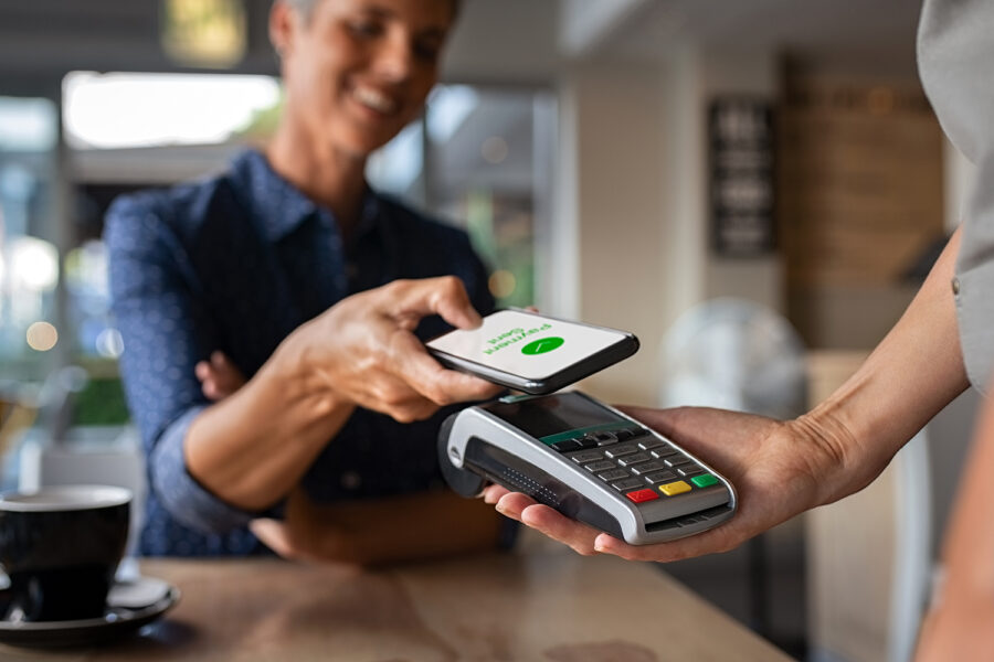 una mujer realiza un pago con su smartphone con tecnología NFC