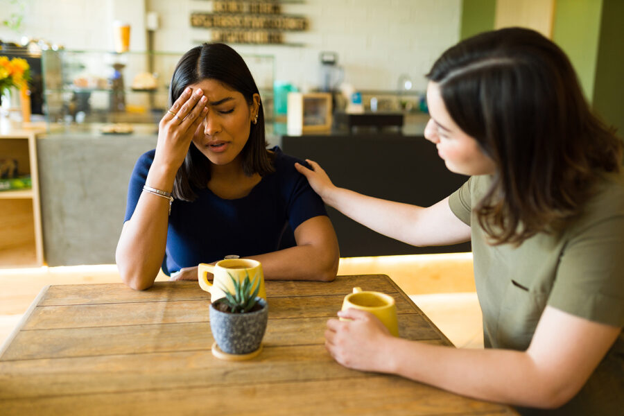 una mujer mexicana triste es consolada por una amiga