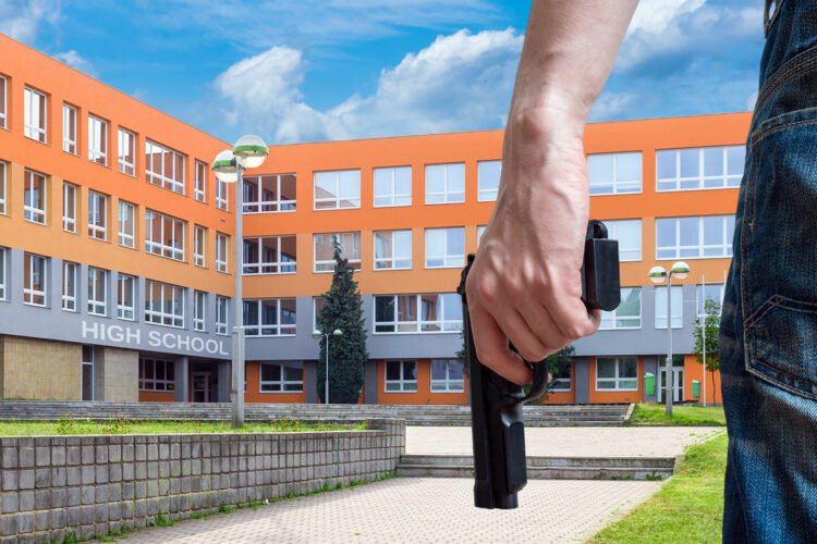 un tirador activo sujeta una pistola en una high school