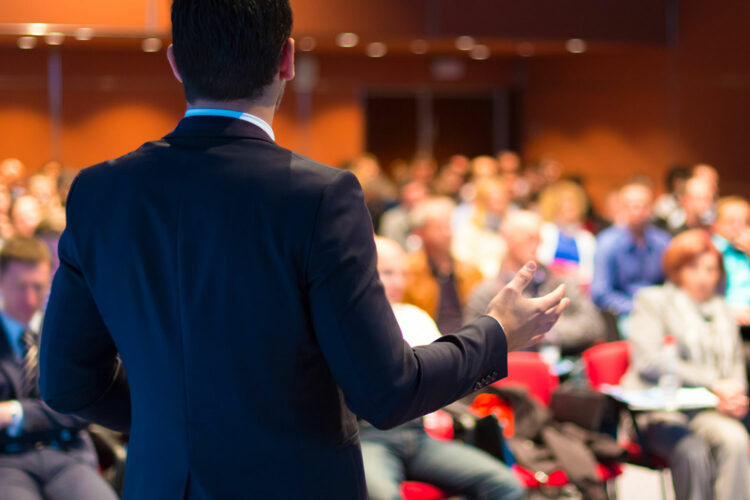 un hombre imparte una conferencia en un salón de actos