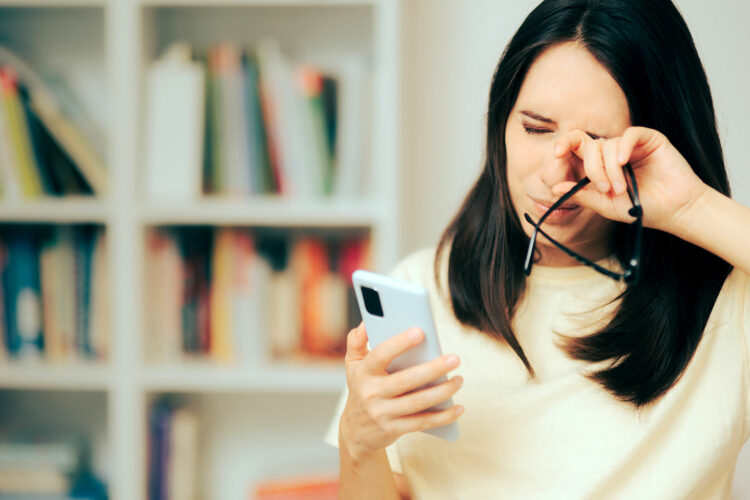 una mujer sufre cansancio por el uso excesivo del teléfono móvil