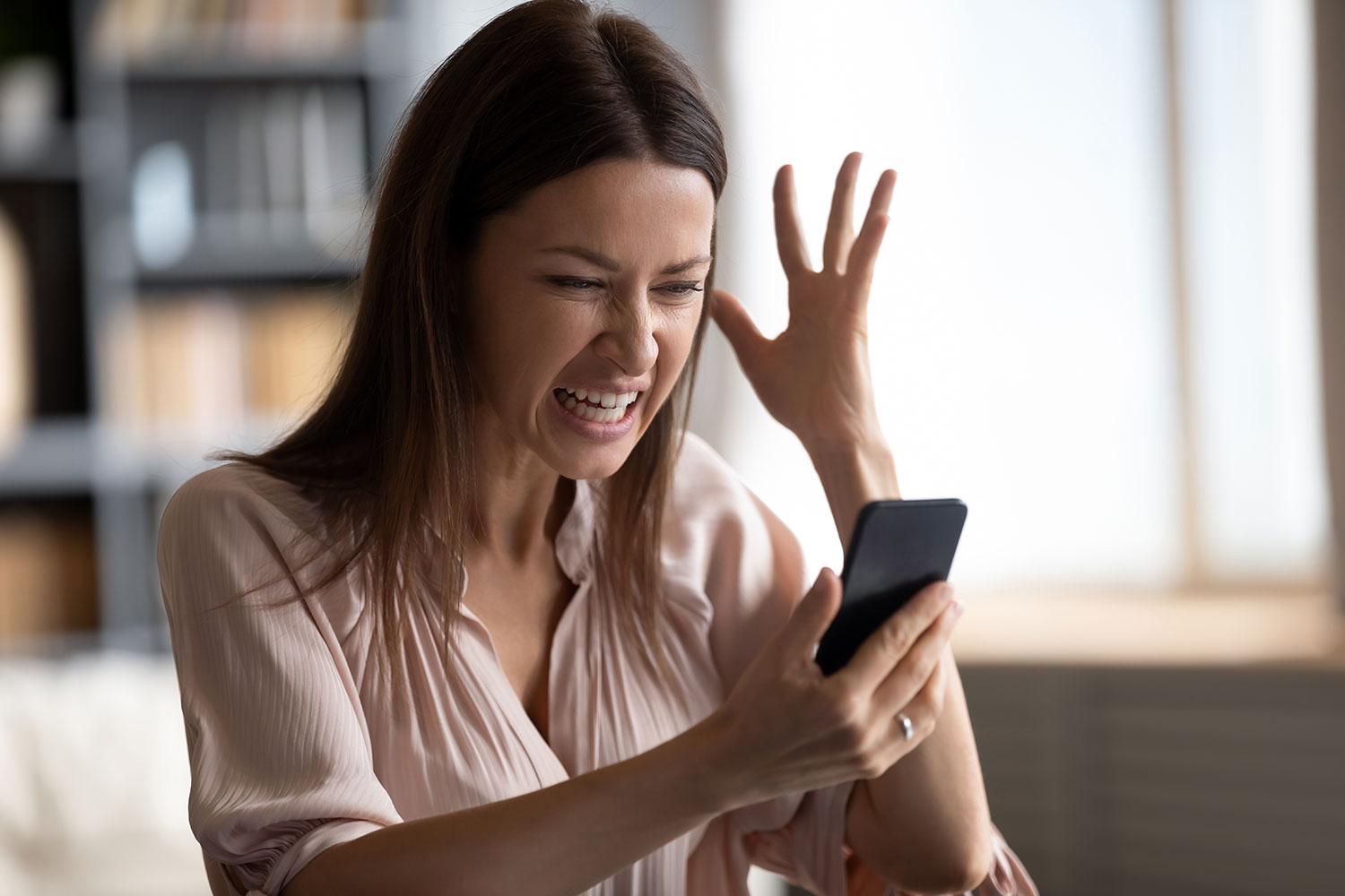 una mujer enfadada mira su smartphone
