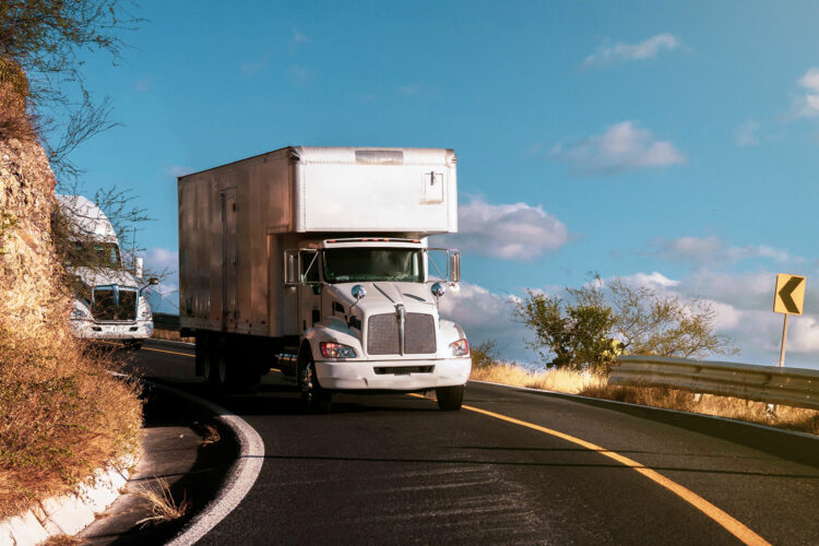 dos camiones de mercancías circulan por una carretera de México