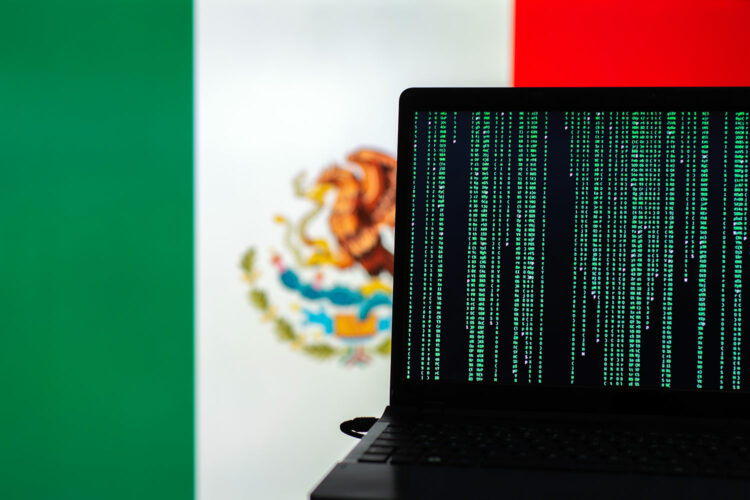 un ordenador portátil junto a la bandera mexicana
