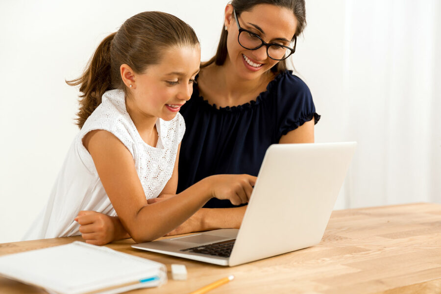 una niña aprende a utilizar el ordenador y navegar por Internet junto a su madre