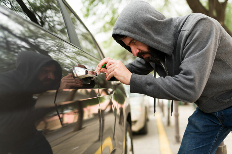 un ladrón intenta forzar la cerradura de un automóvil