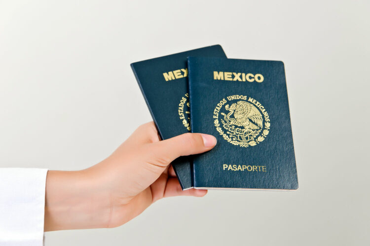una mujer sostiene dos pasaportes mexicanos en la mano