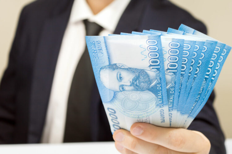 Un hombre sostiene billetes de 10.000 pesos chilenos en la mano