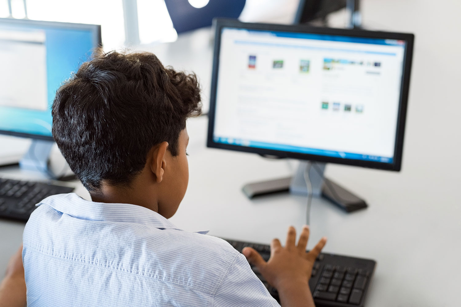 un niño aprende a manejar un ordenador en el colegio