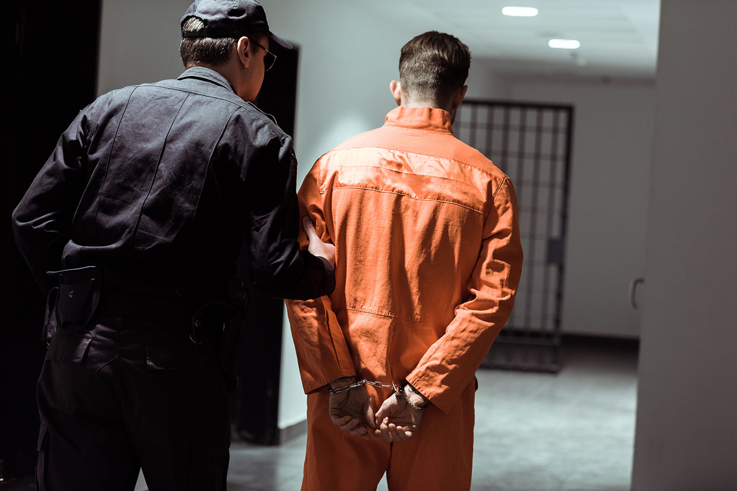 un trabajador del sector de la vigilancia y seguridad privada acompaña a un recluso en una prisión