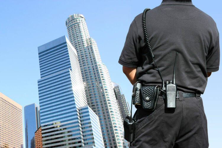 un guardia de seguridad privada ante unos edificios de oficinas