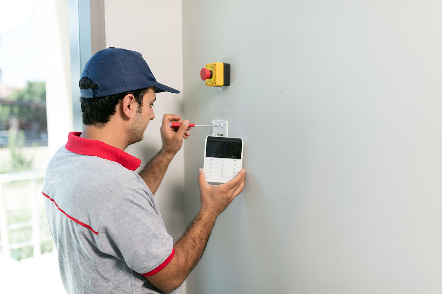 Un profesional instala el panel de un sistema de alarma en la pared