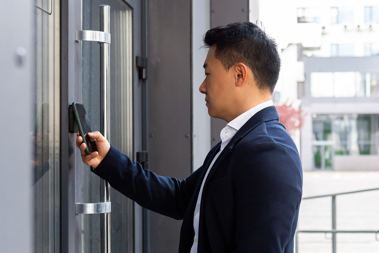 Un hombre accede a un edificio de oficinas sirviéndose de la función NFC de su teléfono inteligente