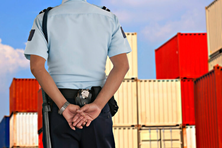 un guardia de seguridad privada prestar servicio en una instalación logística de contenedores