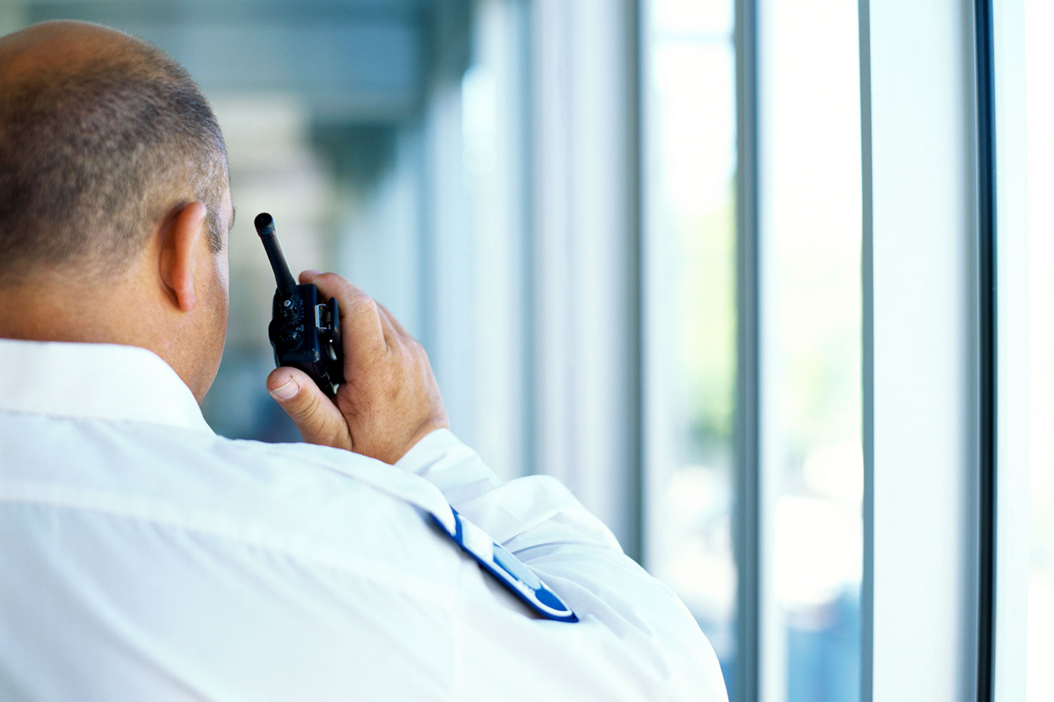 un guardia de seguridad privada se comunica mediante un walkie talkie