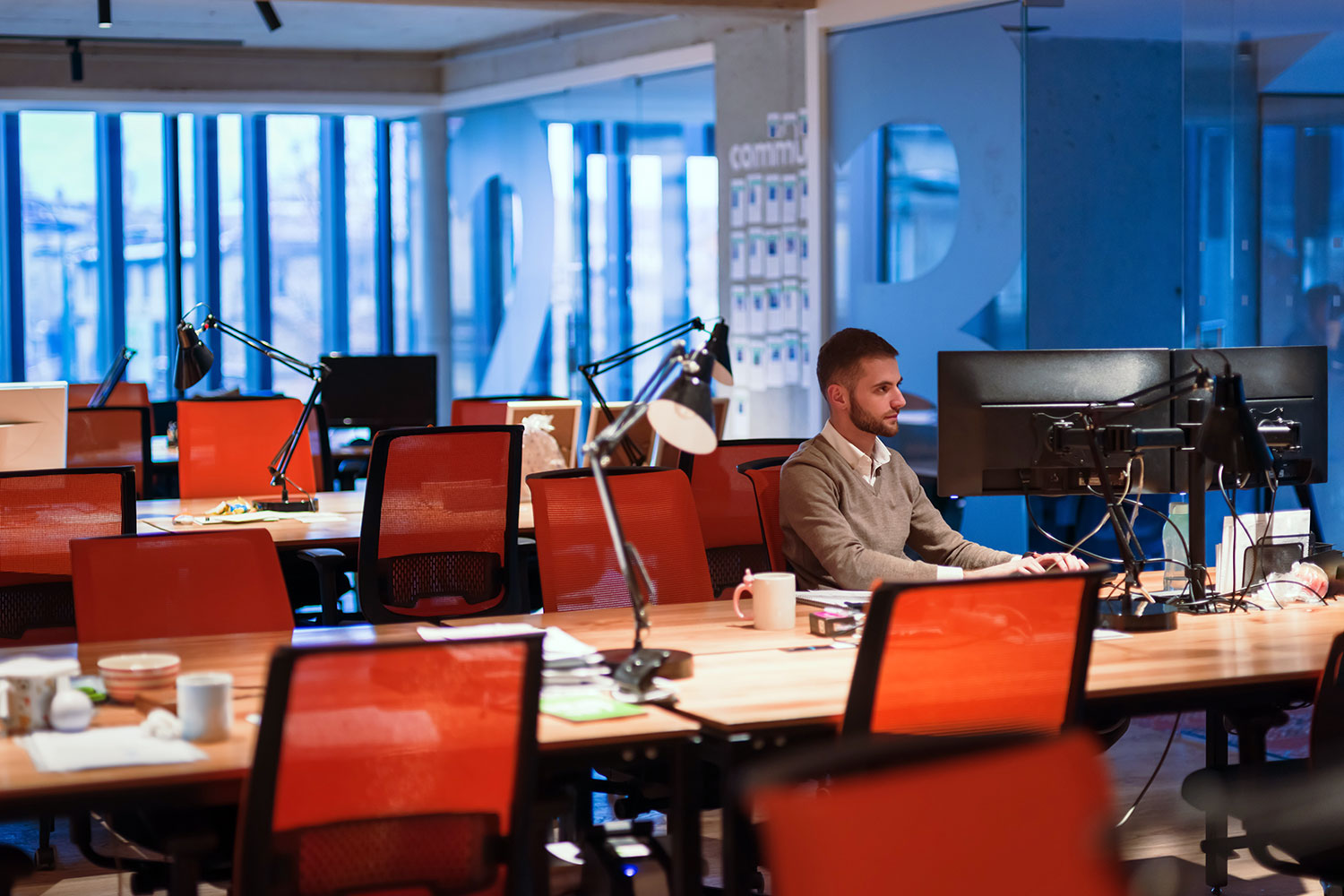 An employee works with his computer in a half-empty office