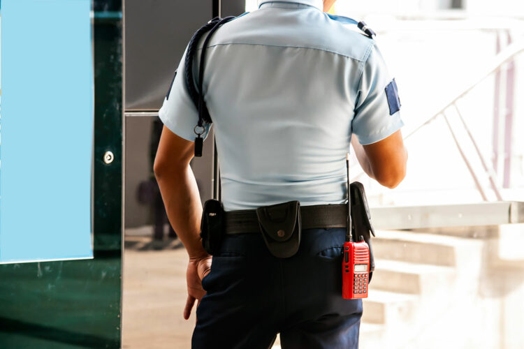 una guardia de seguridad privada presta servicio en un edificio corporativo