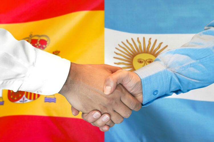 apretón de manos entre representantes de España y Argentina
