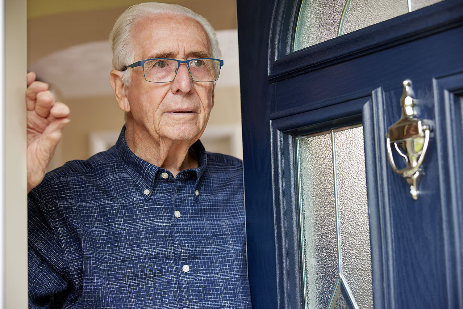 un anciano abre la puerta de su casa a una persona desconocida