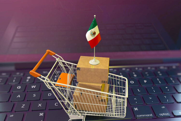 un carrito de compra con una bandera de México sobre el teclado de una computadora portátil