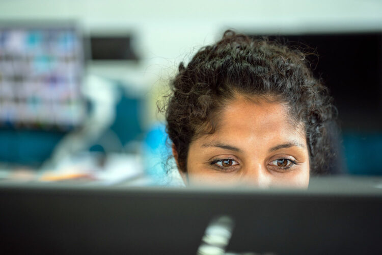 una mujer trabaja frente a un monitor de ordenador