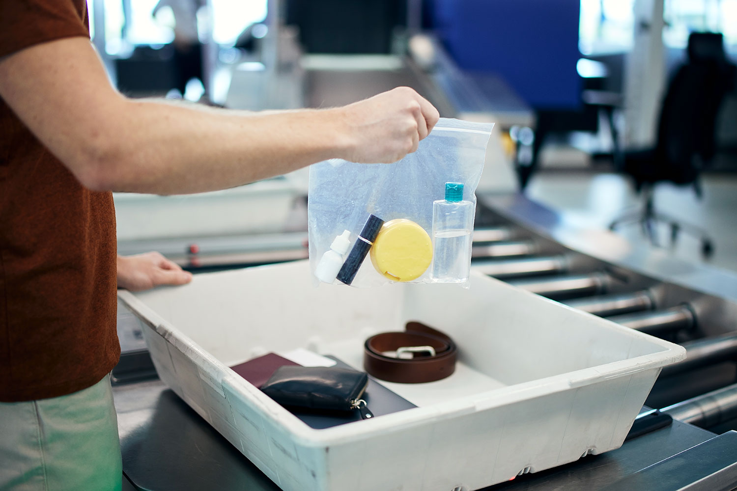 un hombre muestra una bolsa de plástico con líquidos en el control de seguridad del aeropuerto