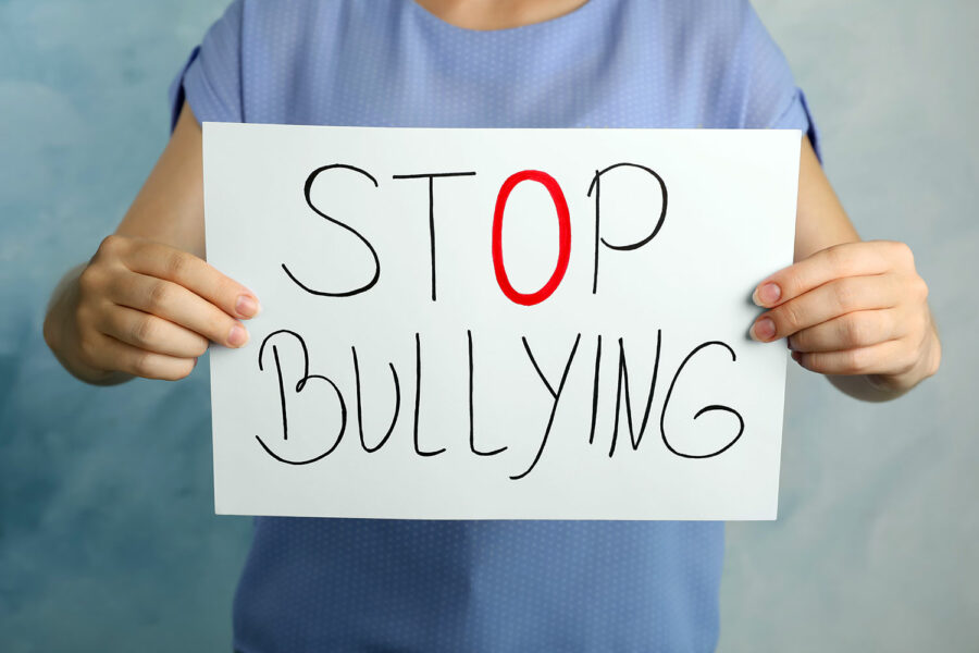 una mujer sujeta un cartel con la leyenda Stop Bullying
